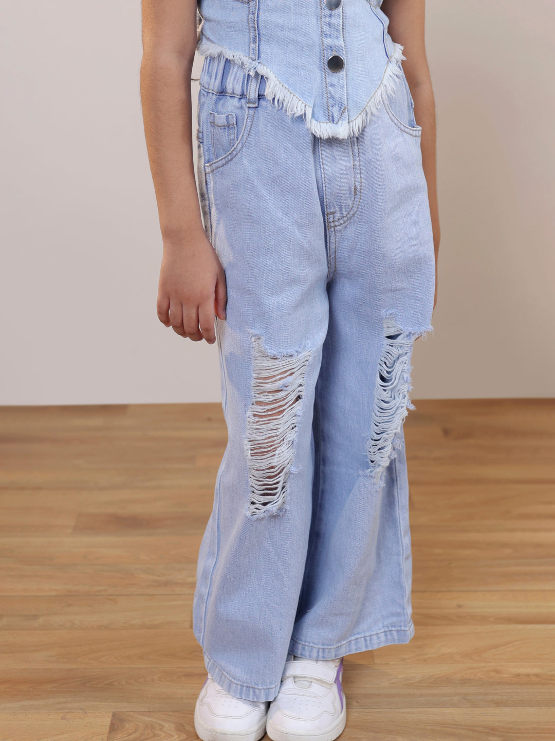 Sleeveless solid denim vest and ripped denim pants